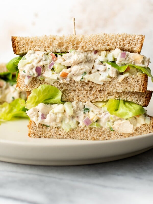 two classic chicken salad sandwiches stacked on top of each other