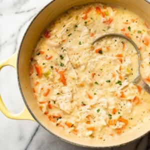 close-up of creamy chicken rice soup in a pot with a ladle