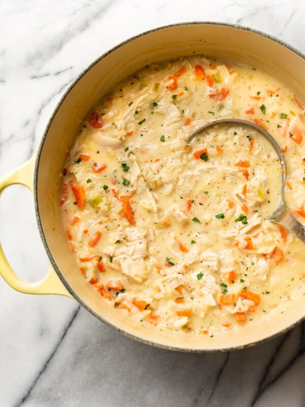 close-up of creamy chicken rice soup in a pot with a ladle