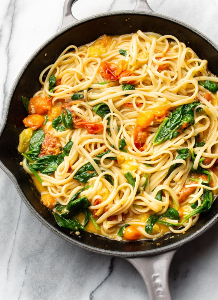 garlic butter pasta with fresh tomatoes tossed with linguine in a skillet