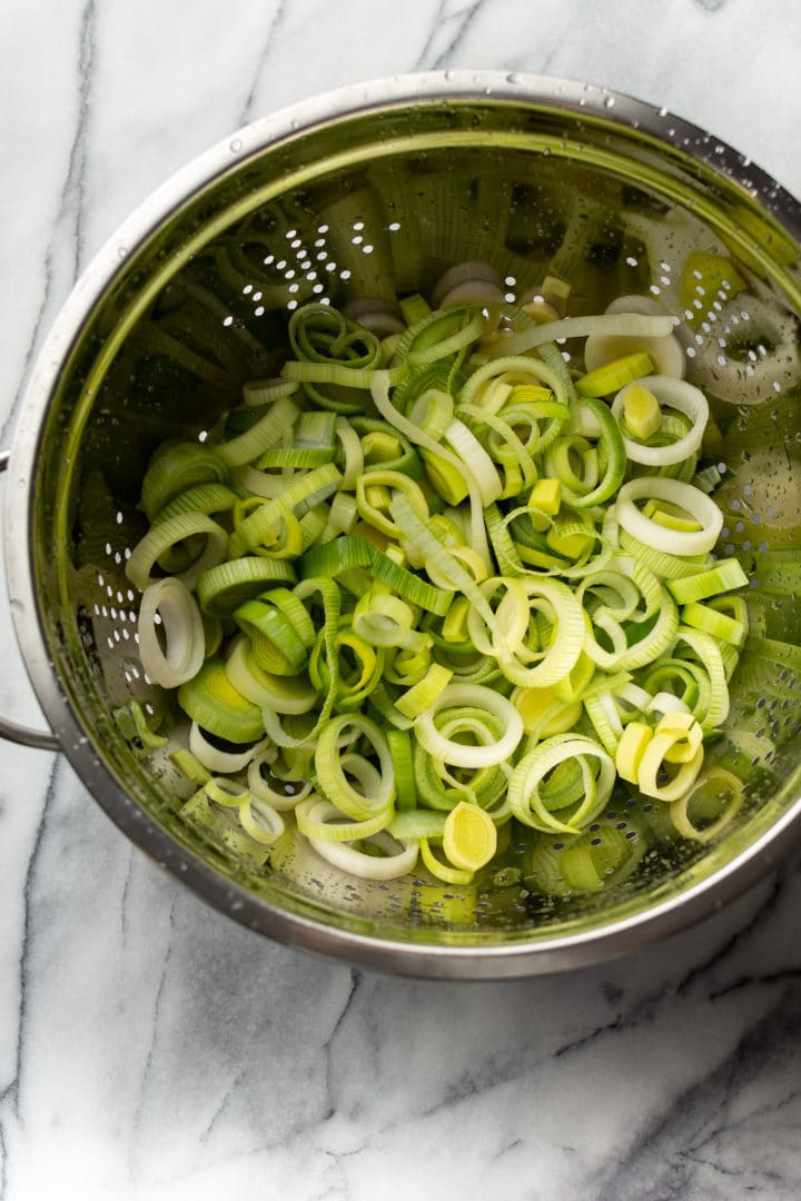 sliced leeks in a metal colander