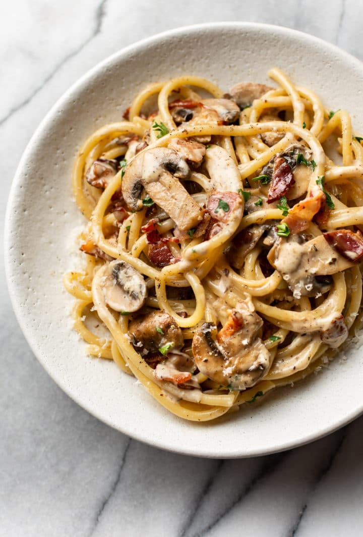 creamy bacon and mushroom pasta in a shallow bowl