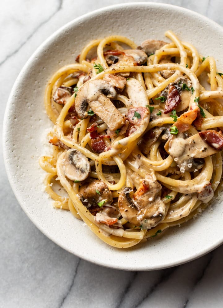 creamy bacon and mushroom pasta in a shallow bowl