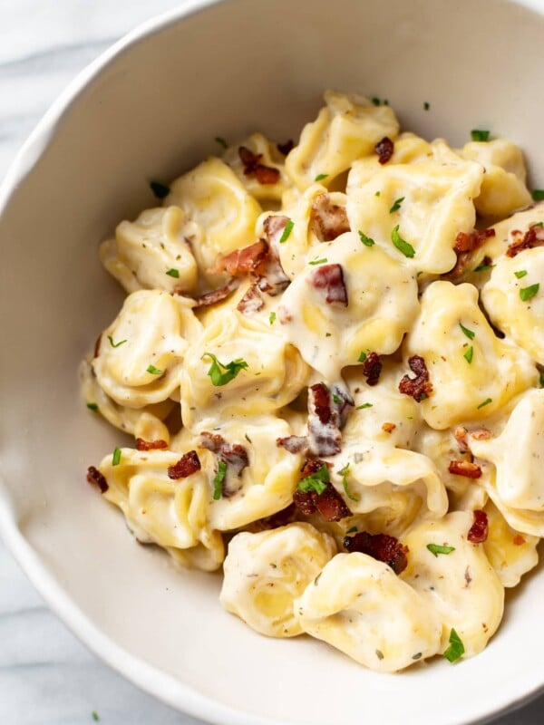close-up of creamy ranch tortellini with bacon in a white bowl
