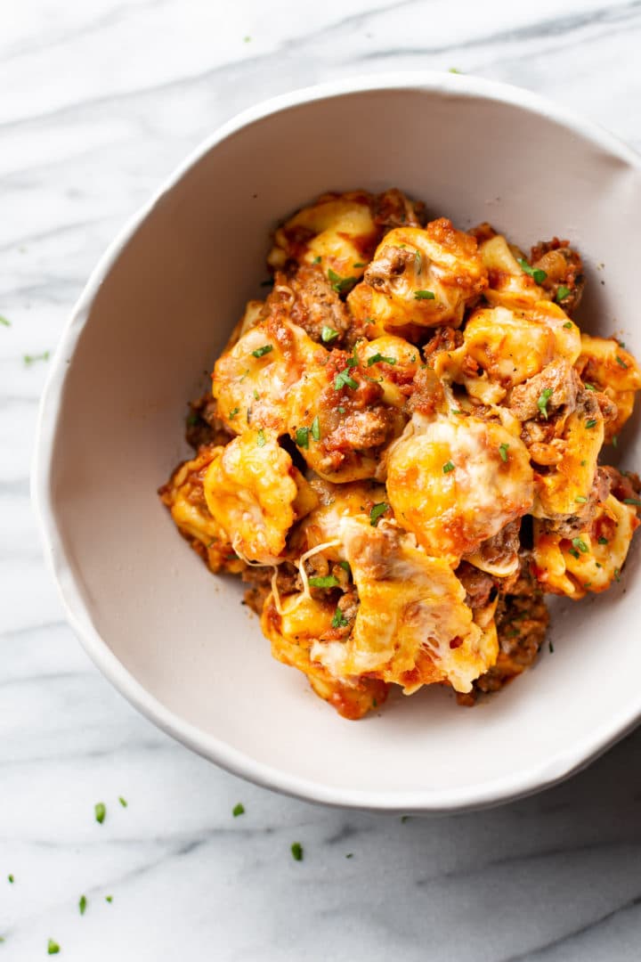 baked tortellini with meat and tomato sauce in a white bowl