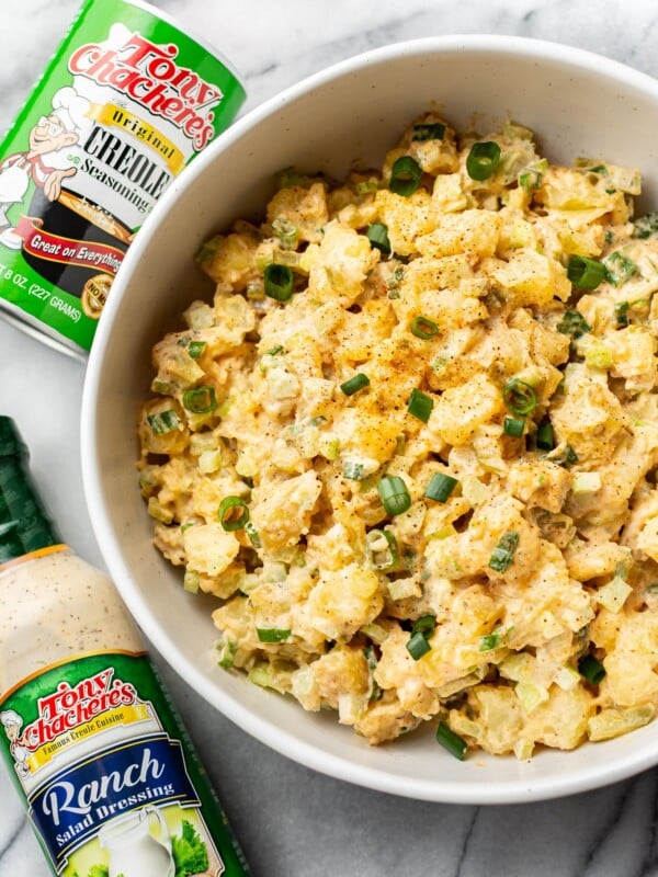 Creole ranch potato salad in a serving bowl with Tony Chachere's Original Creole Seasoning shaker container and Tony's Ranch Dressing bottle