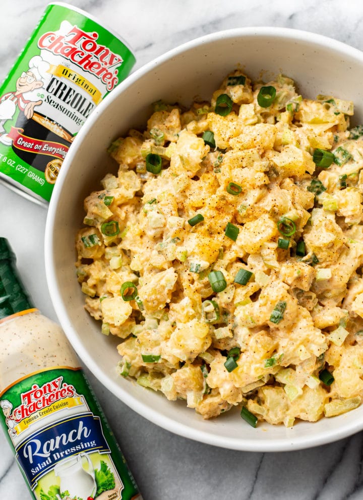 Creole ranch potato salad in a serving bowl with Tony Chachere's Original Creole Seasoning shaker container and Tony's Ranch Dressing bottle