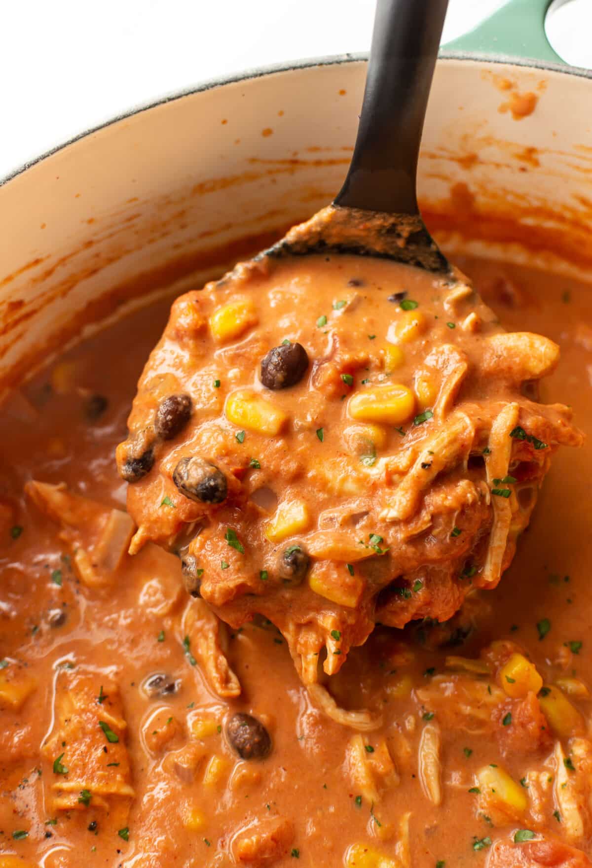 closeup of a pot of creamy chicken tortilla soup with a ladle