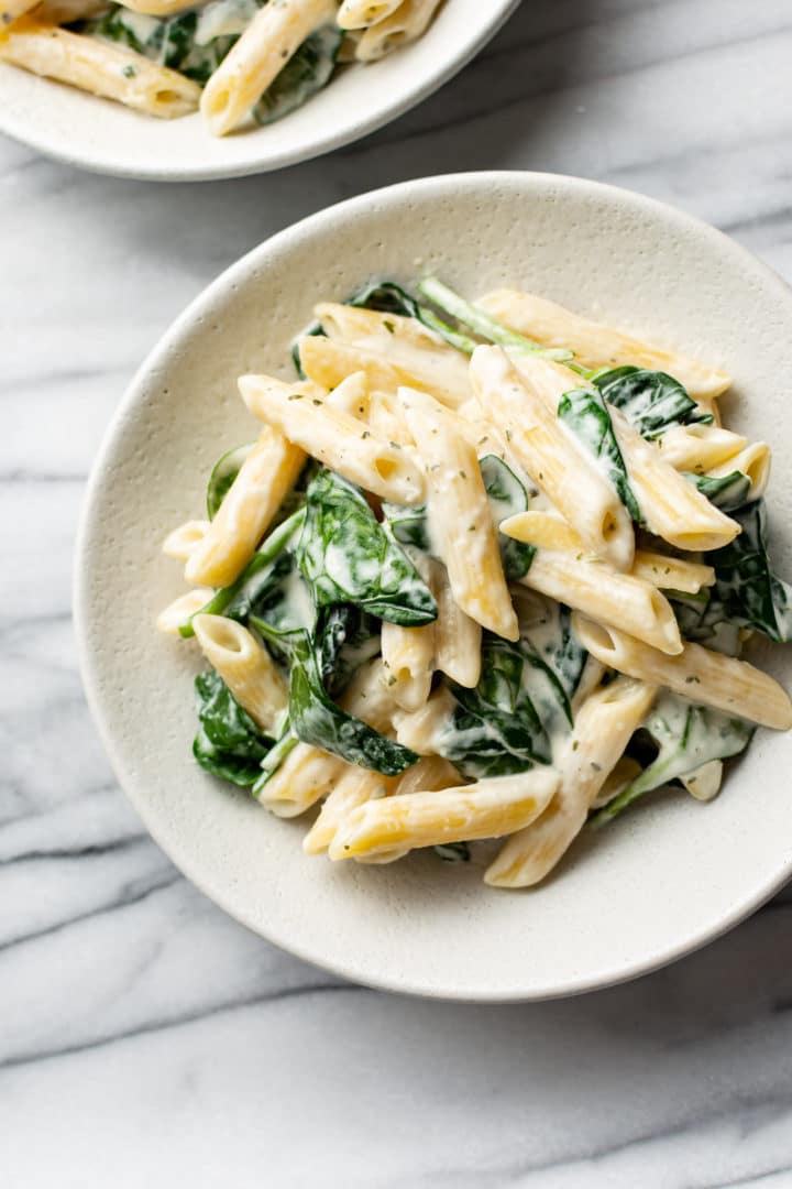 Boursin cheese pasta in two shallow white bowls