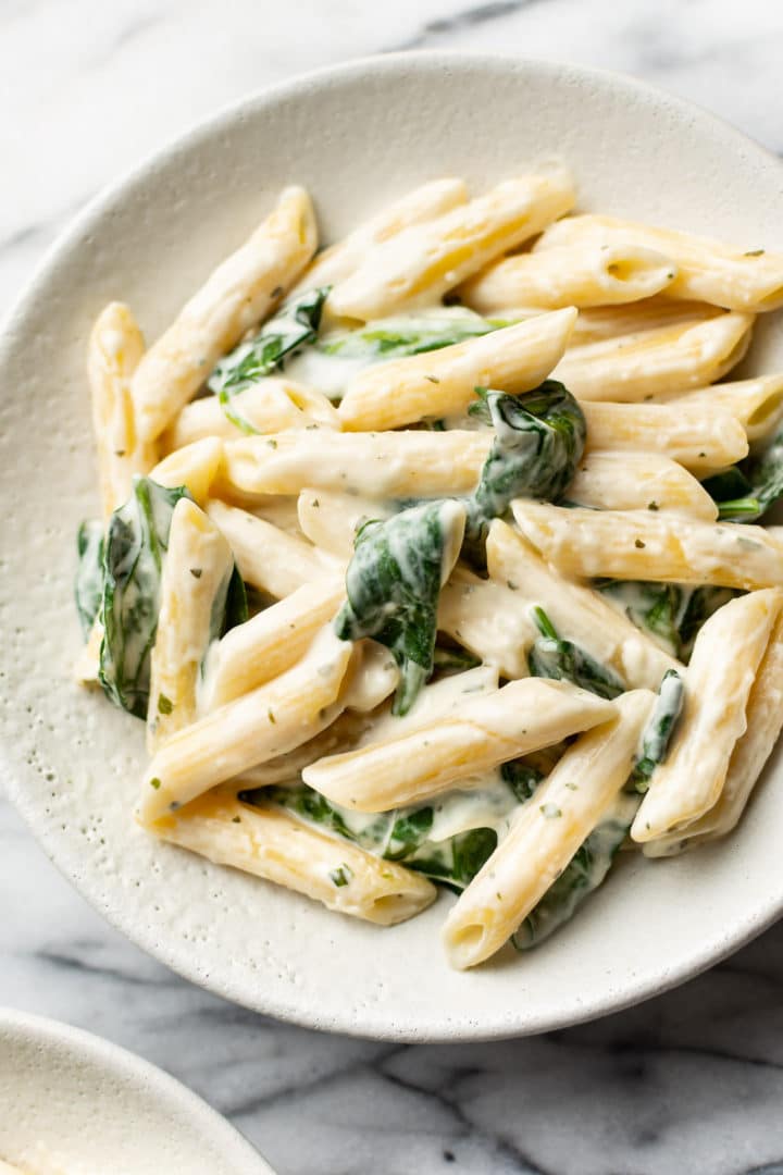 close-up of creamy Boursin pasta with spinach in a shallow bowl