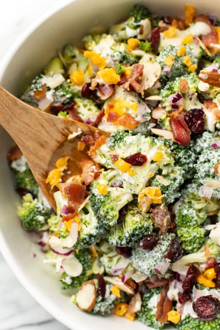 broccoli salad with wooden salad utensils