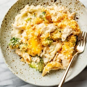 close-up of a shallow bowl with creamy chicken and broccoli casserole and mashed potatoes