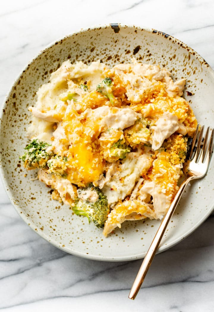 close-up of a shallow bowl with creamy chicken and broccoli casserole and mashed potatoes