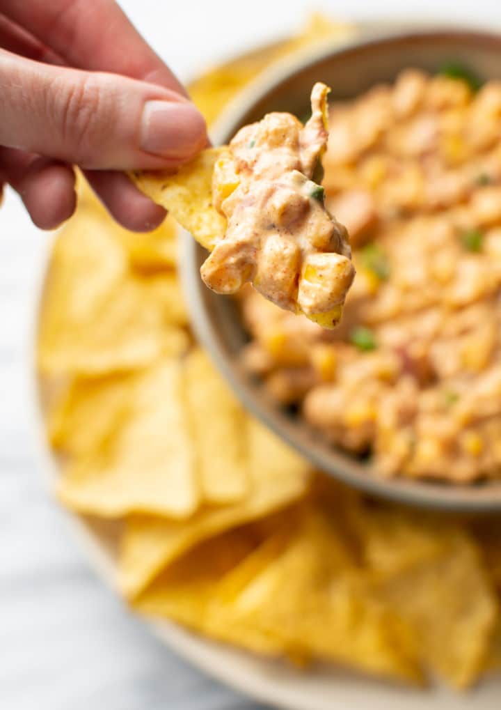 tortilla chip scooping out some cream cheese corn dip