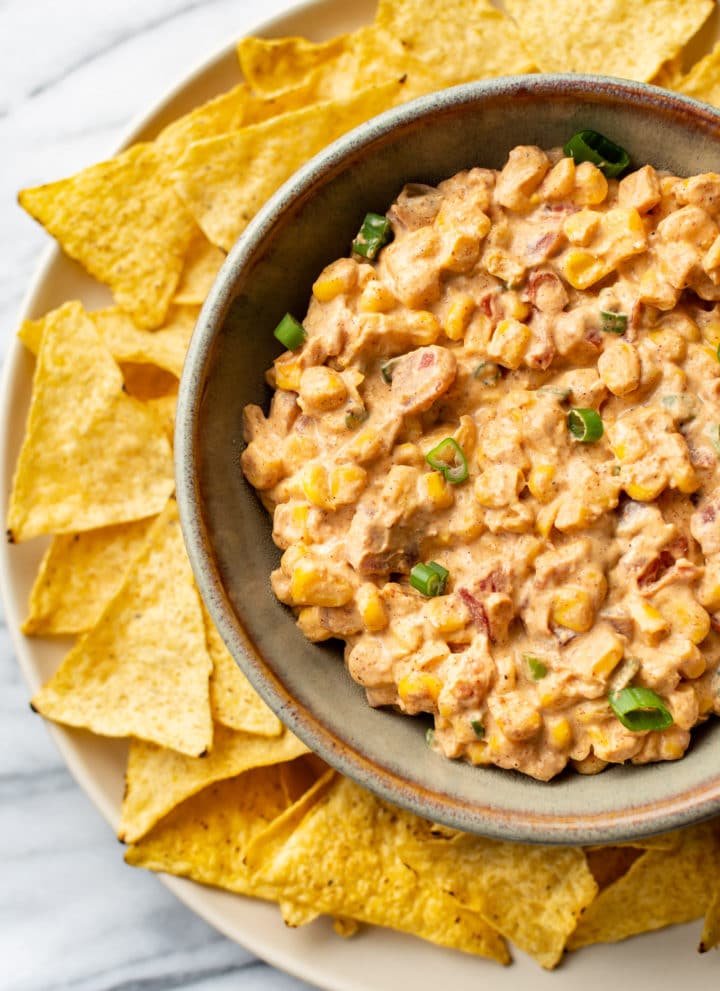 Rotel cream cheese corn dip in a bowl surrounded by tortilla chips