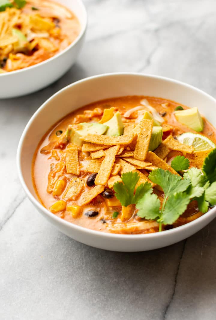 creamy chicken tortilla soup in two white bowls