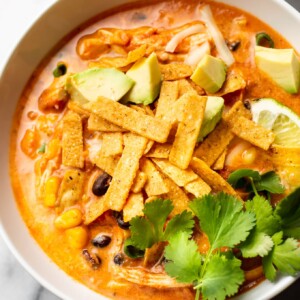 close-up of easy creamy chicken tortilla soup loaded with toppings