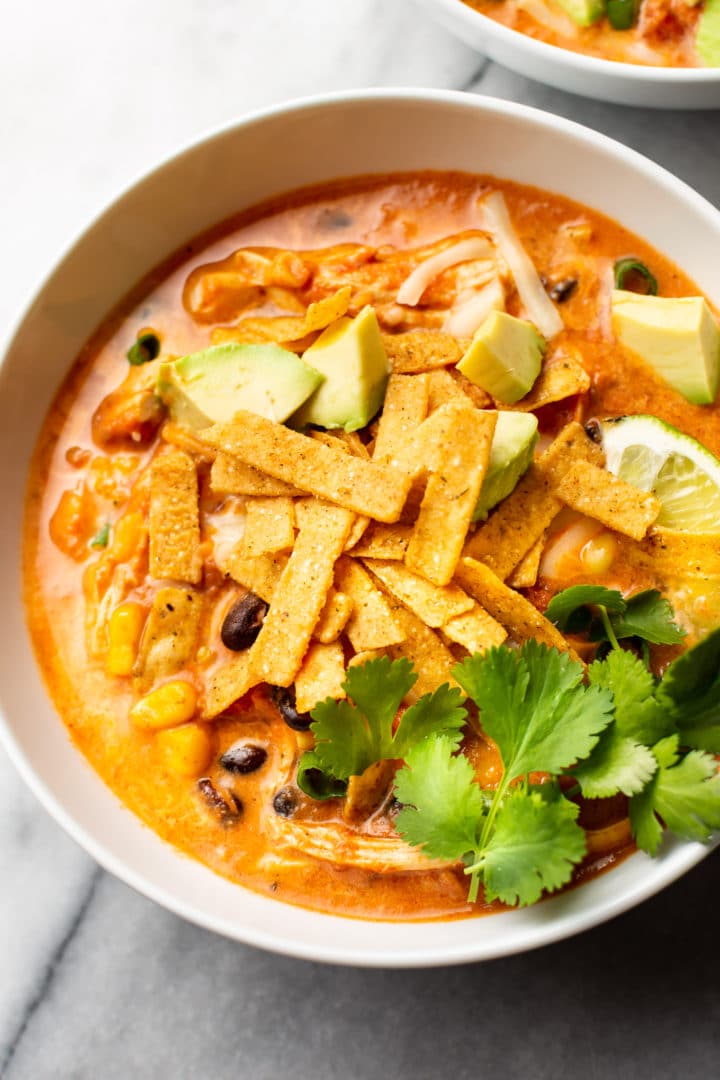 close-up of easy creamy chicken tortilla soup loaded with toppings