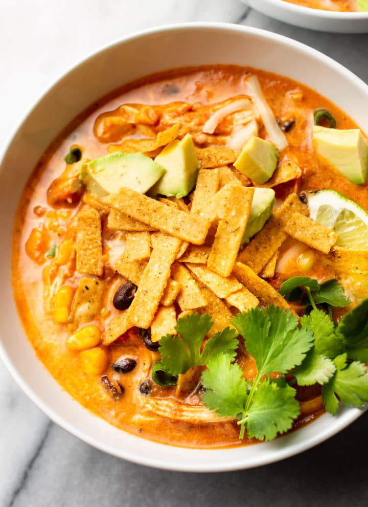 close-up of easy creamy chicken tortilla soup loaded with toppings