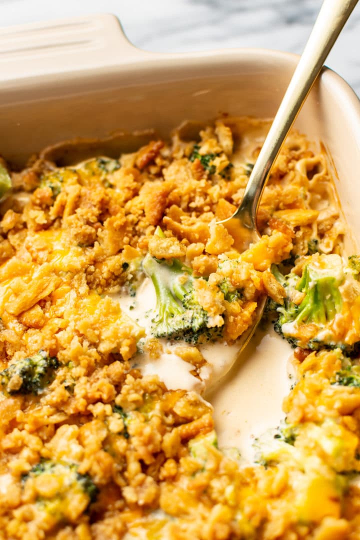 broccoli cheese casserole close-up with a spoonful being lifted out of casserole dish