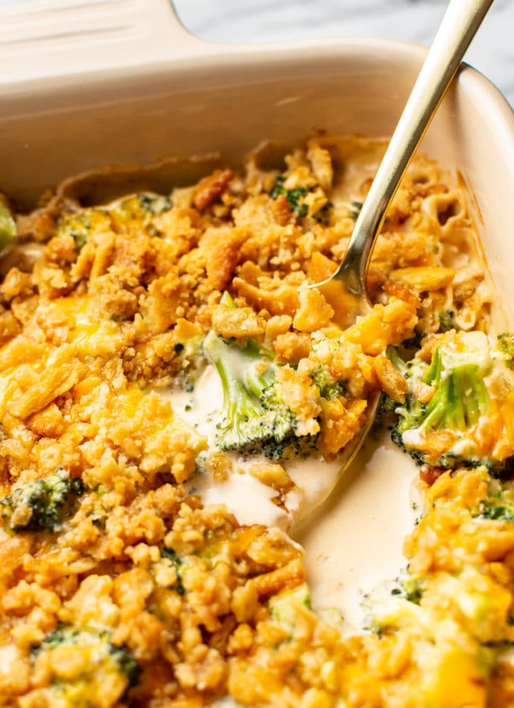 broccoli cheese casserole close-up with a spoonful being lifted out of casserole dish