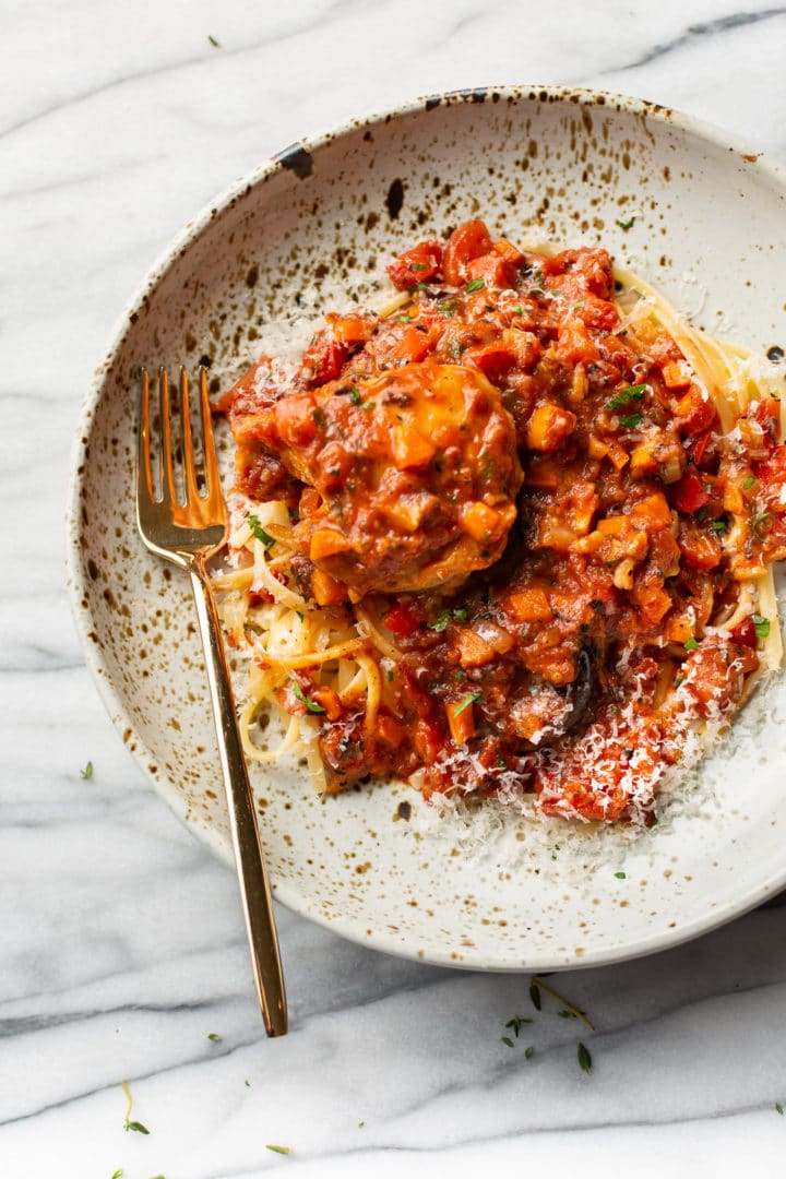 Chicken Cacciatore in a shallow bowl served over linguine