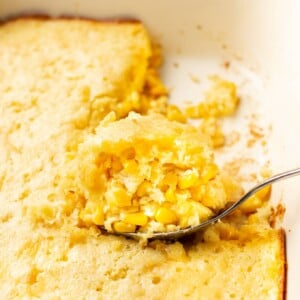 Jiffy corn casserole close-up with a portion being lifted out of the baking dish