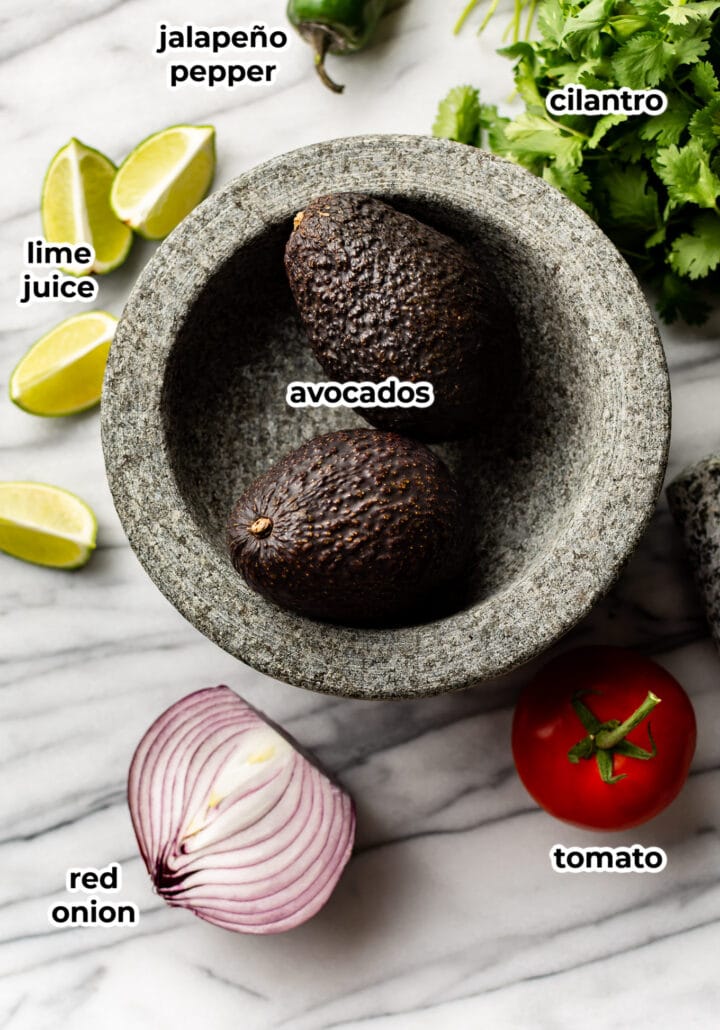 ingredients for guacamole on a marble surface
