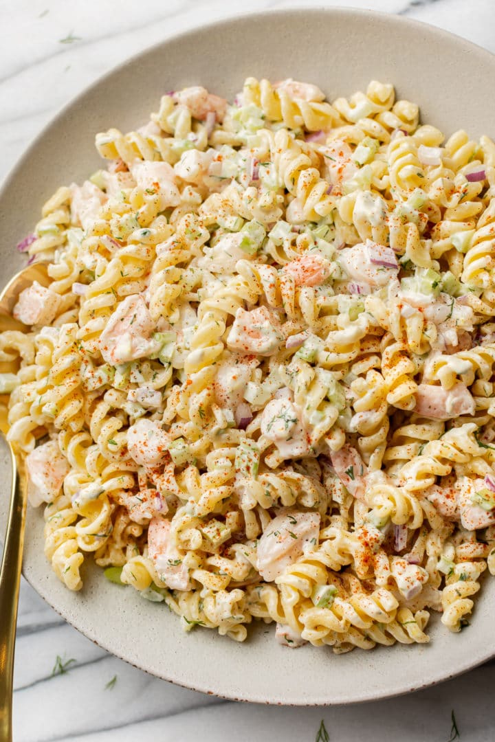 cold shrimp pasta salad in a shallow serving bowl