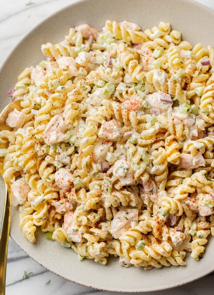 cold shrimp pasta salad in a shallow serving bowl