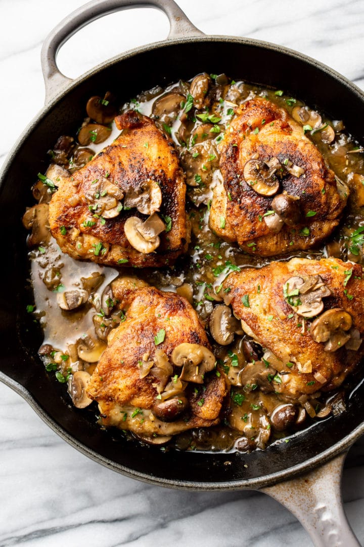 crispy white wine mushroom chicken thighs in a skillet