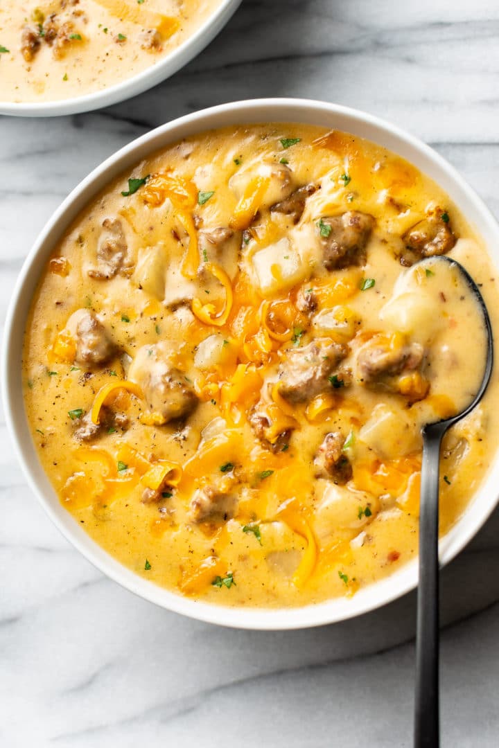 cheesy sausage potato soup in two white bowls