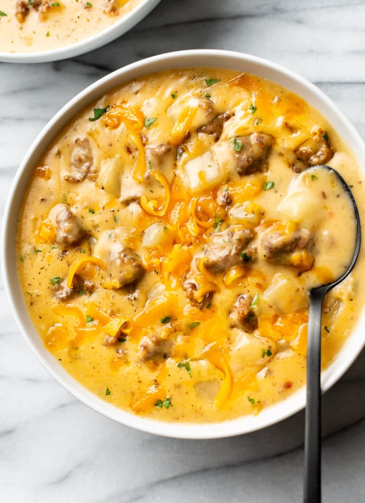 cheesy sausage potato soup in two white bowls