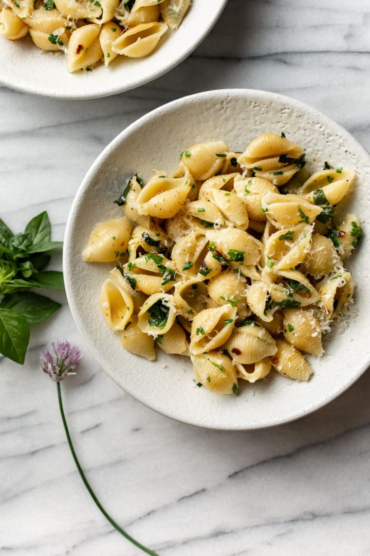 herb butter pasta in two white bowls