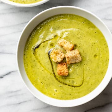 zucchini soup in two white bowls