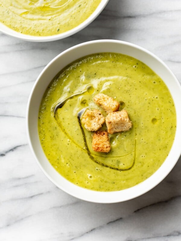 zucchini soup in two white bowls