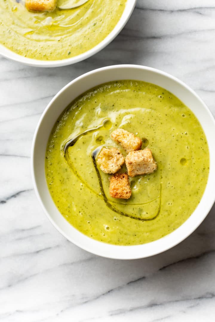 zucchini soup in two white bowls