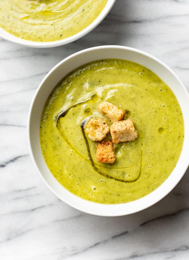 zucchini soup in two white bowls