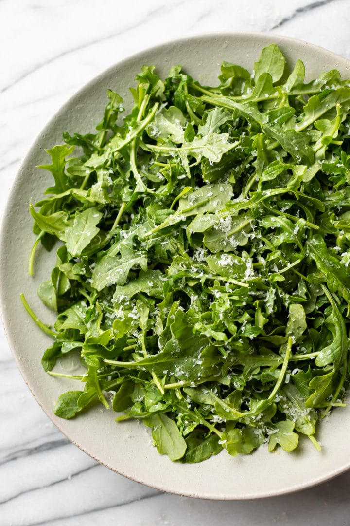 the best arugula salad in a shallow serving bowl