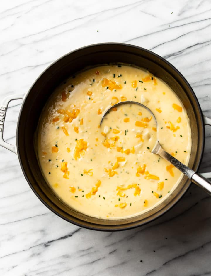 cheddar potato soup in a pot with a ladle