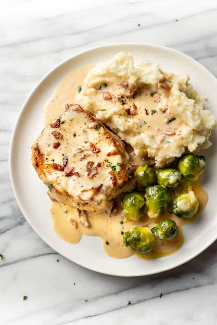 creamy bacon pork chops with mashed potatoes and Brussels sprouts