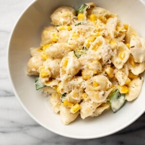 creamy corn pasta in two white bowls