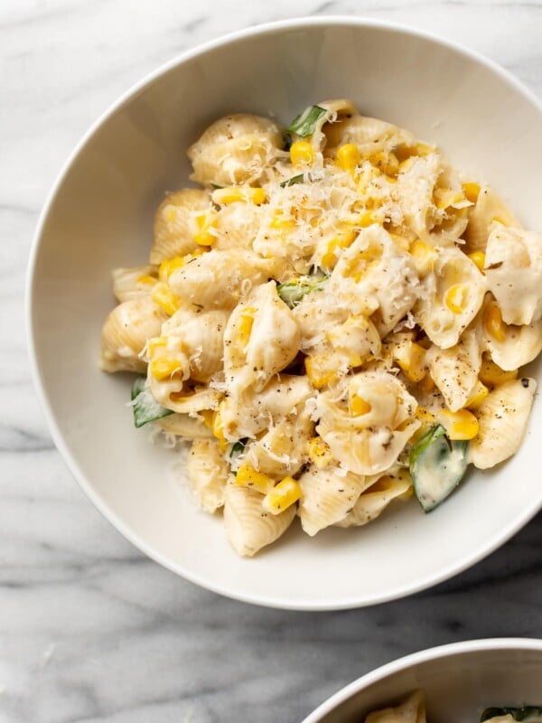 creamy corn pasta in two white bowls