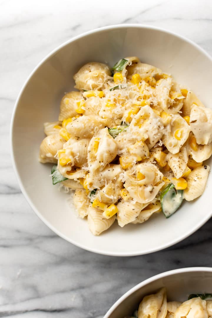 creamy corn pasta in two white bowls