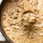 closeup of a skillet of hamburger gravy with a serving spoon