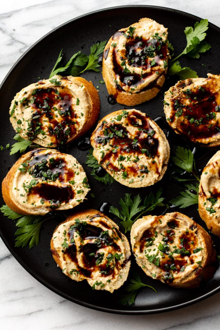 hummus crostini on a black plate