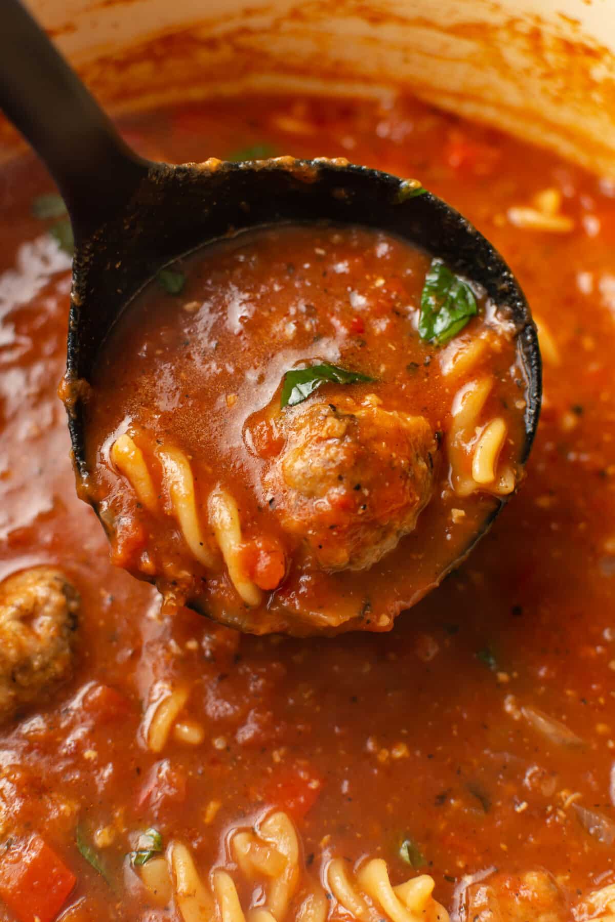 closeup of a ladle with meatball soup