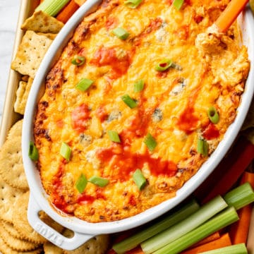 buffalo chicken dip surrounded by veggies, crackers, and chips