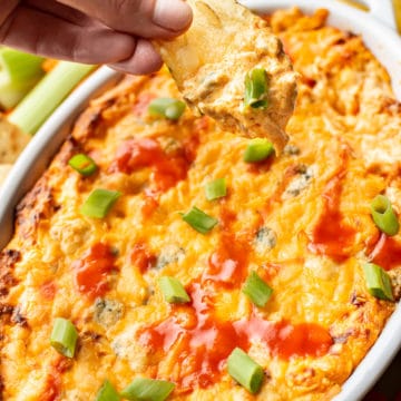a chip being dipped into hot buffalo chicken dip