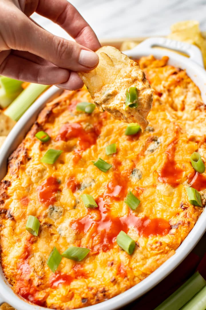 a chip being dipped into hot buffalo chicken dip